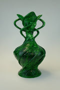 A translucent green sculptural vase with organic, flowing forms and twisted looped handles, photographed against a neutral light gray studio background.