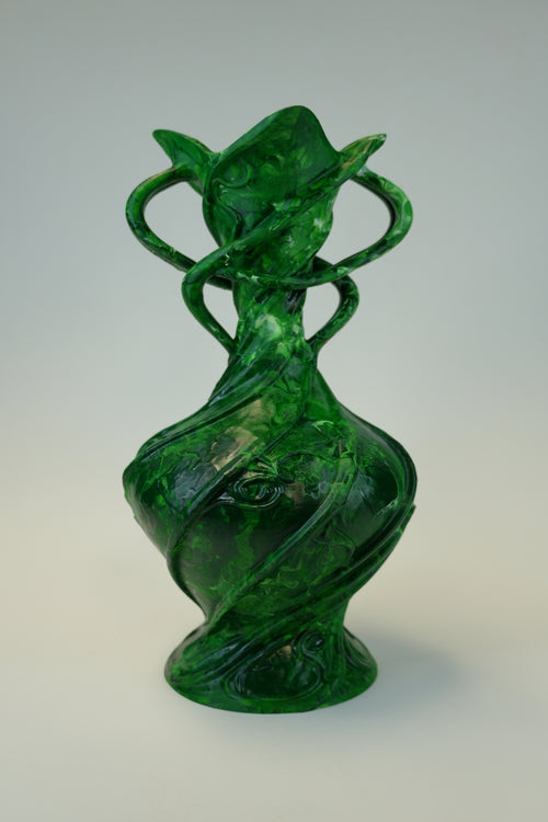 A translucent green sculptural vase with organic, flowing forms and twisted looped handles, photographed against a neutral light gray studio background.