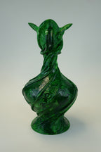 A sculptural green vase with a stylized animal or dragon-like head and curved, twisted body, photographed against a plain light gray studio background.