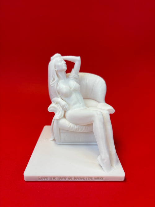 White sculpture of a woman on a chair against a red background