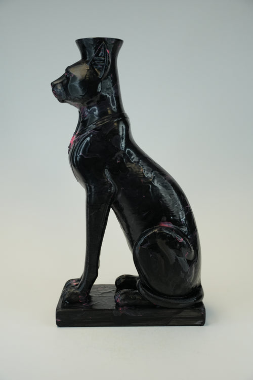 A glossy black cat-shaped vase or sculpture with a flared top, shown in profile on a rectangular base against a light gray studio background.