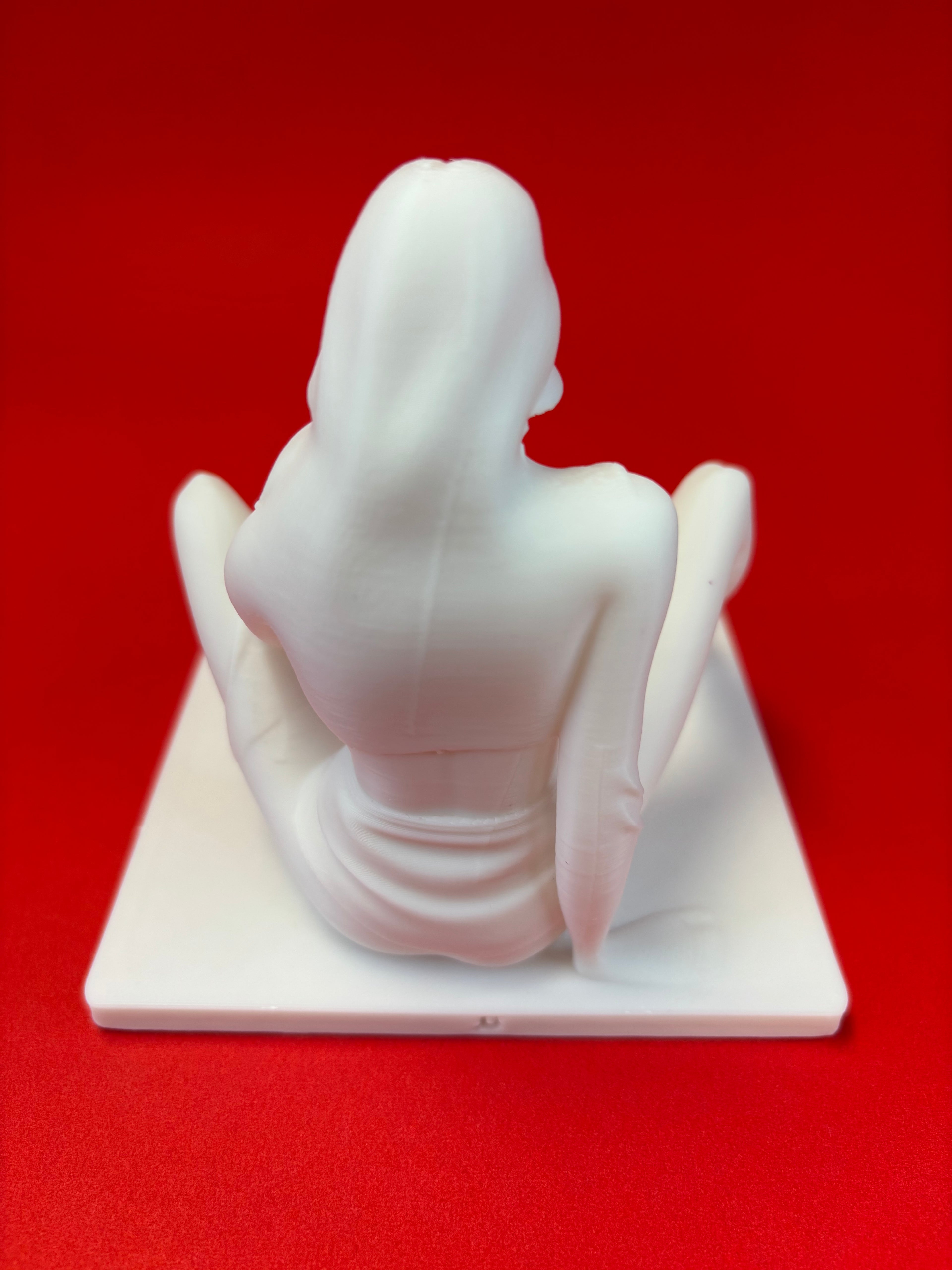 White sculpture against a red background