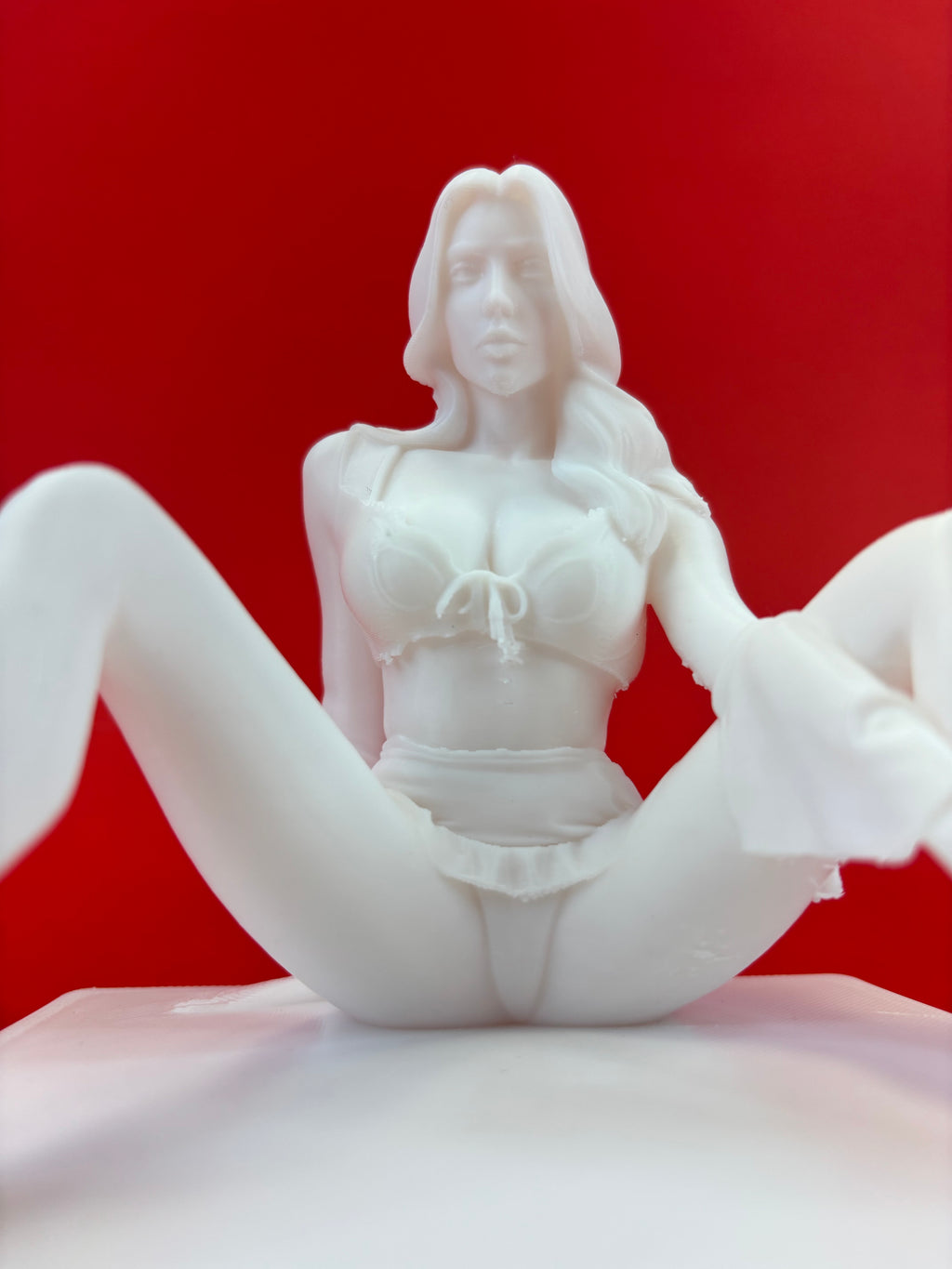 White figurine of a woman on a red background