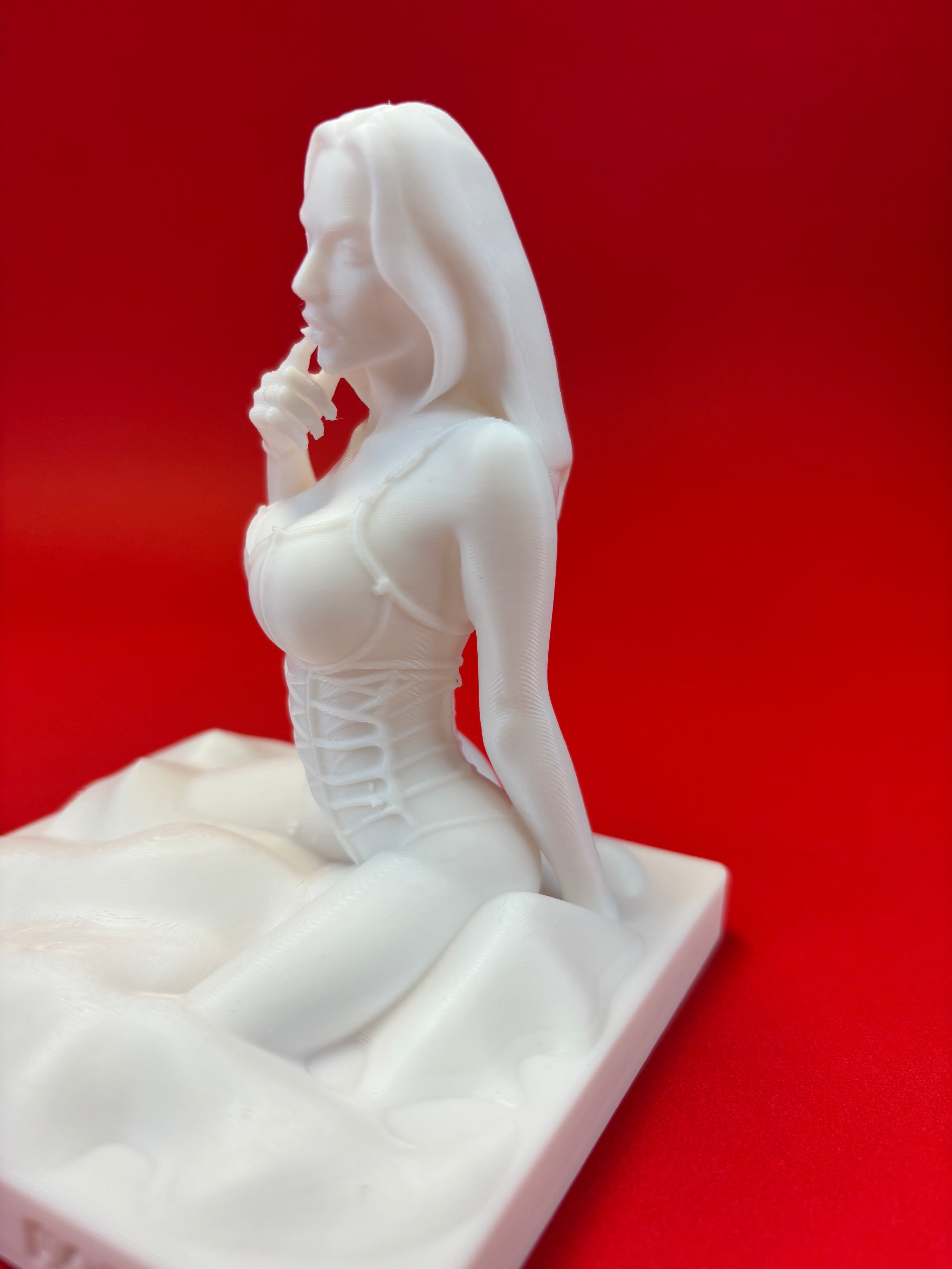White sculpture of a figure on a red background