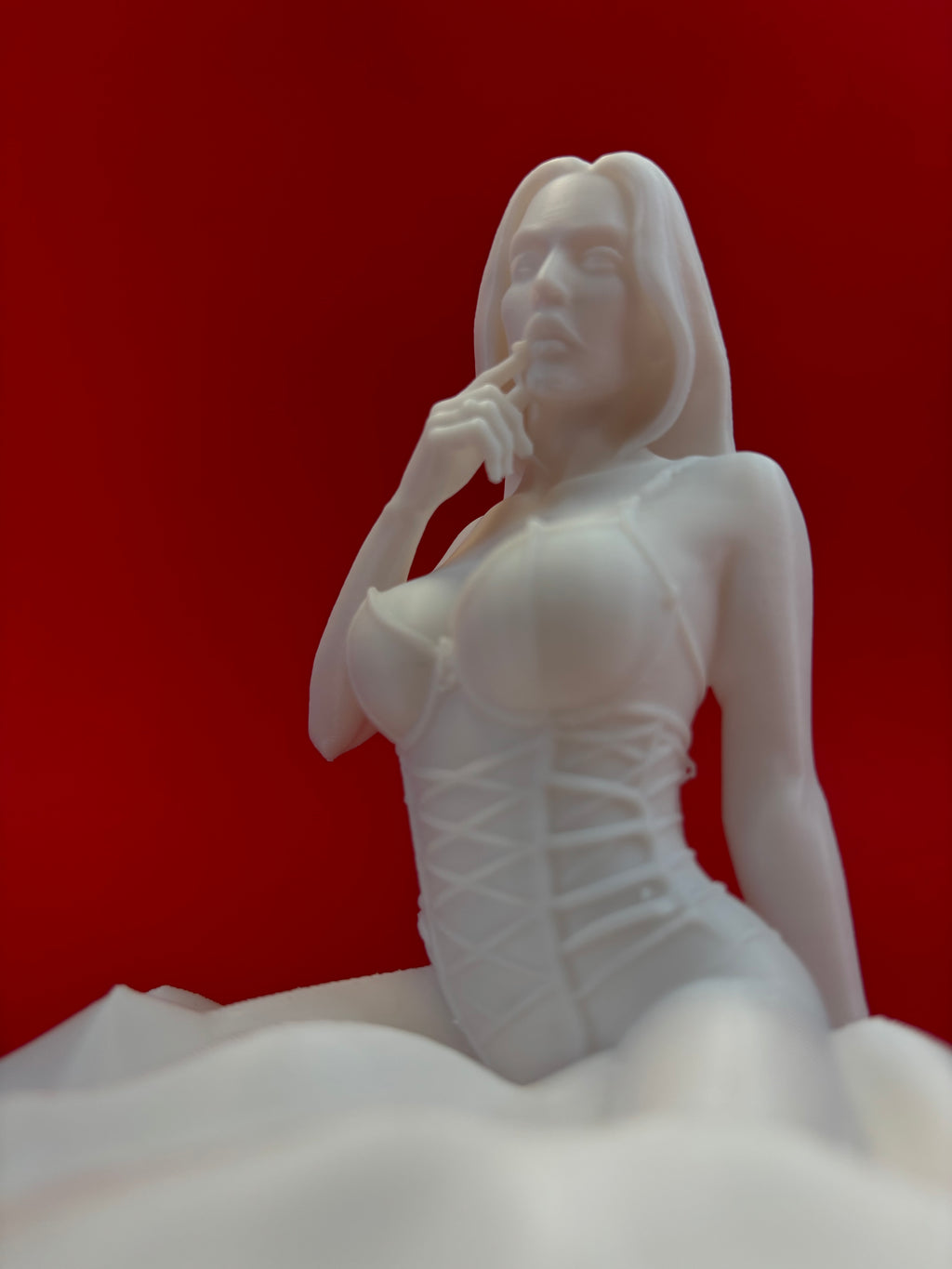White sculpture of a figure on a red background