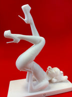 White figurine of a woman on high heels against a red background