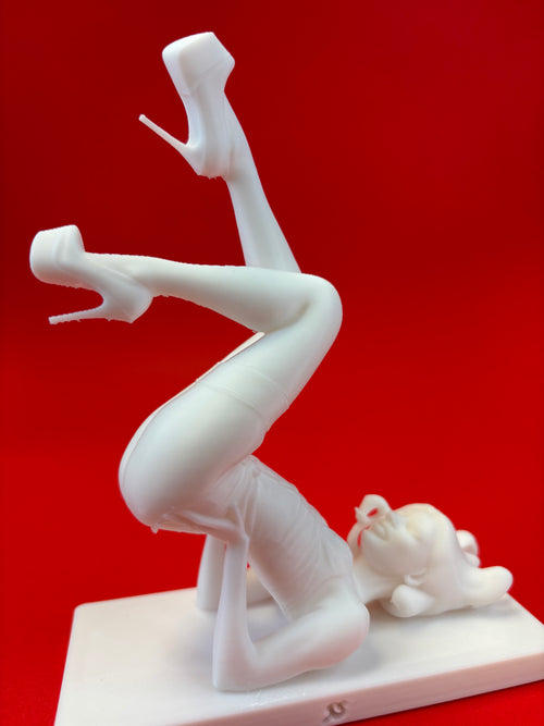 White figurine of a woman on high heels against a red background