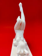 White sculpture of a figure against a red background