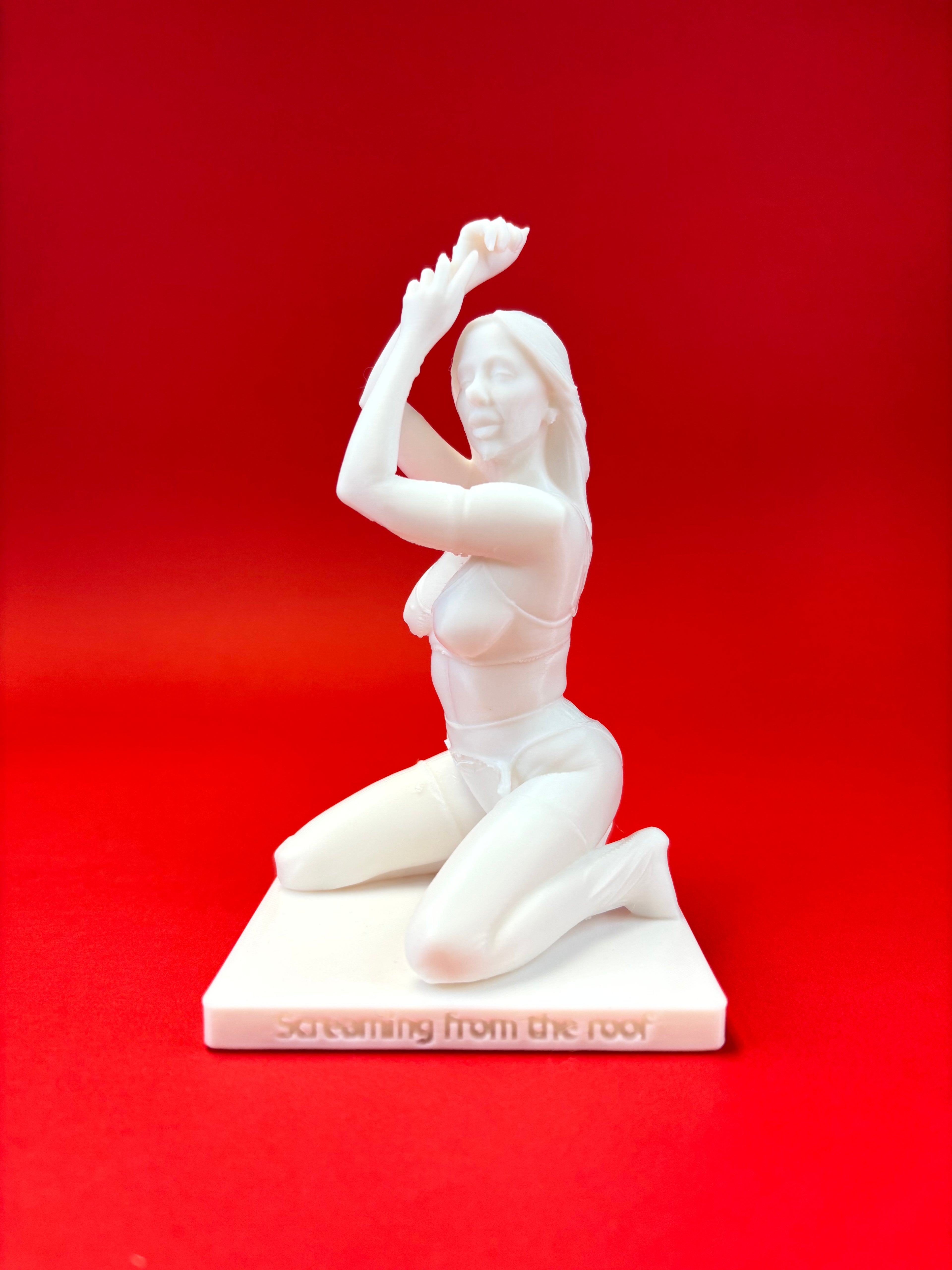 White sculpture of a reclining figure on a red background