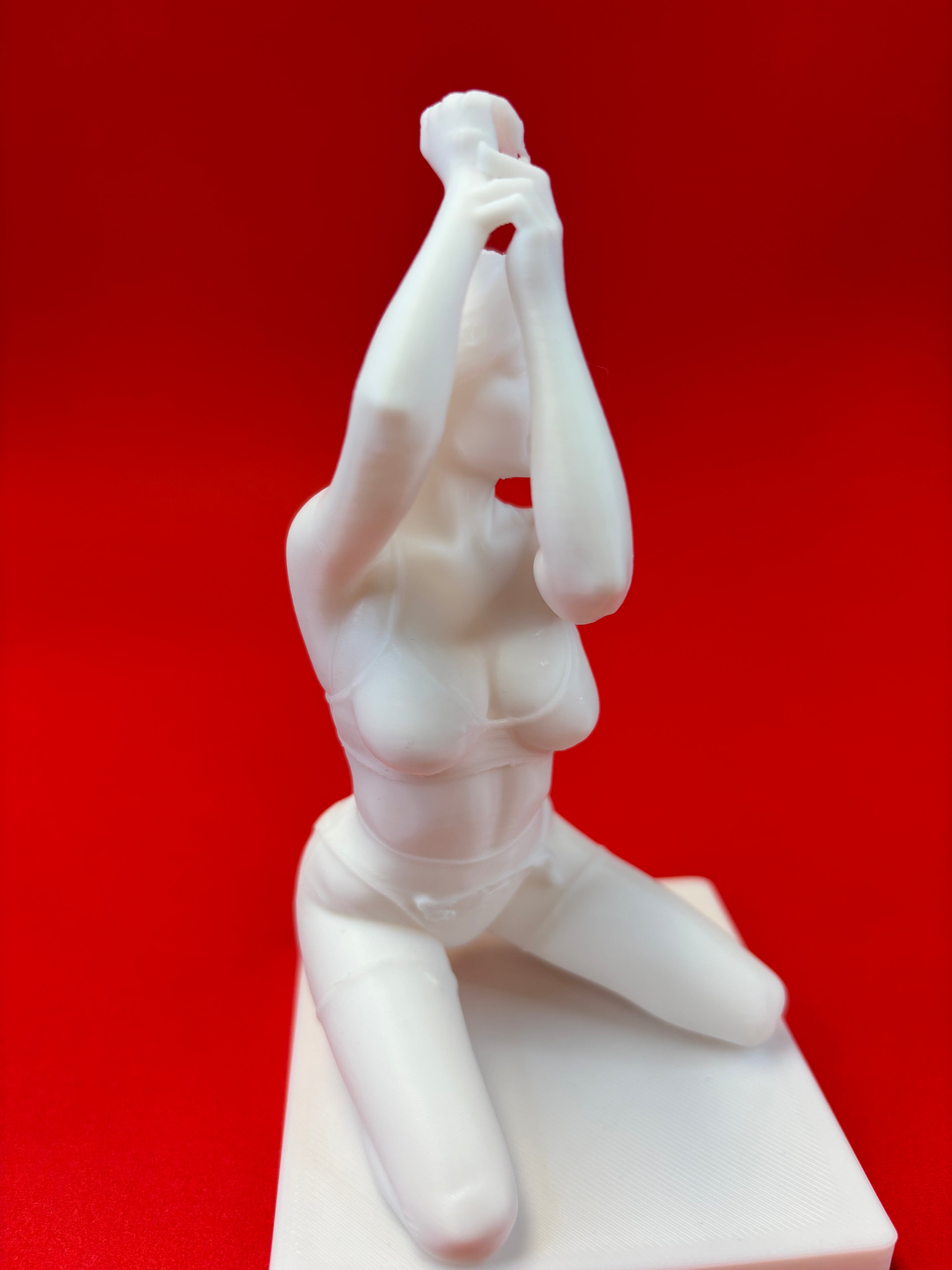 White sculpture of a figure on a red background