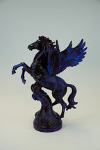 A dark metallic Pegasus figurine with a deep blue and black marbled finish, standing on a textured base against a light gray background.