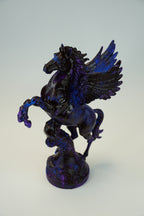 A glossy black and deep blue winged horse figurine, resembling Pegasus, standing on a textured base against a light gray background.