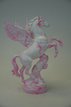 A white and pink marbled Pegasus figurine with wings and a rearing horse design, displayed on a neutral gray background.