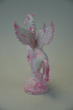 A pink and white swirled pegasus figurine on a matching round base, photographed against a plain light gray background.