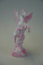 A small white pegasus figurine with pink marbled and splattered details, standing on a matching round base against a plain light gray background.
