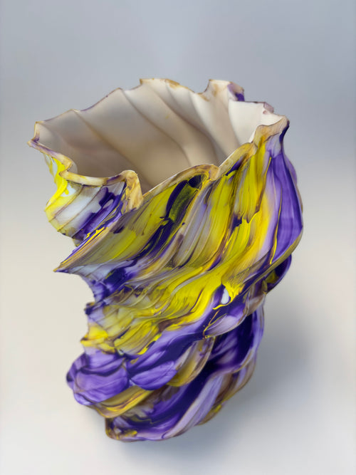 Abstract vase with purple and yellow swirl pattern.