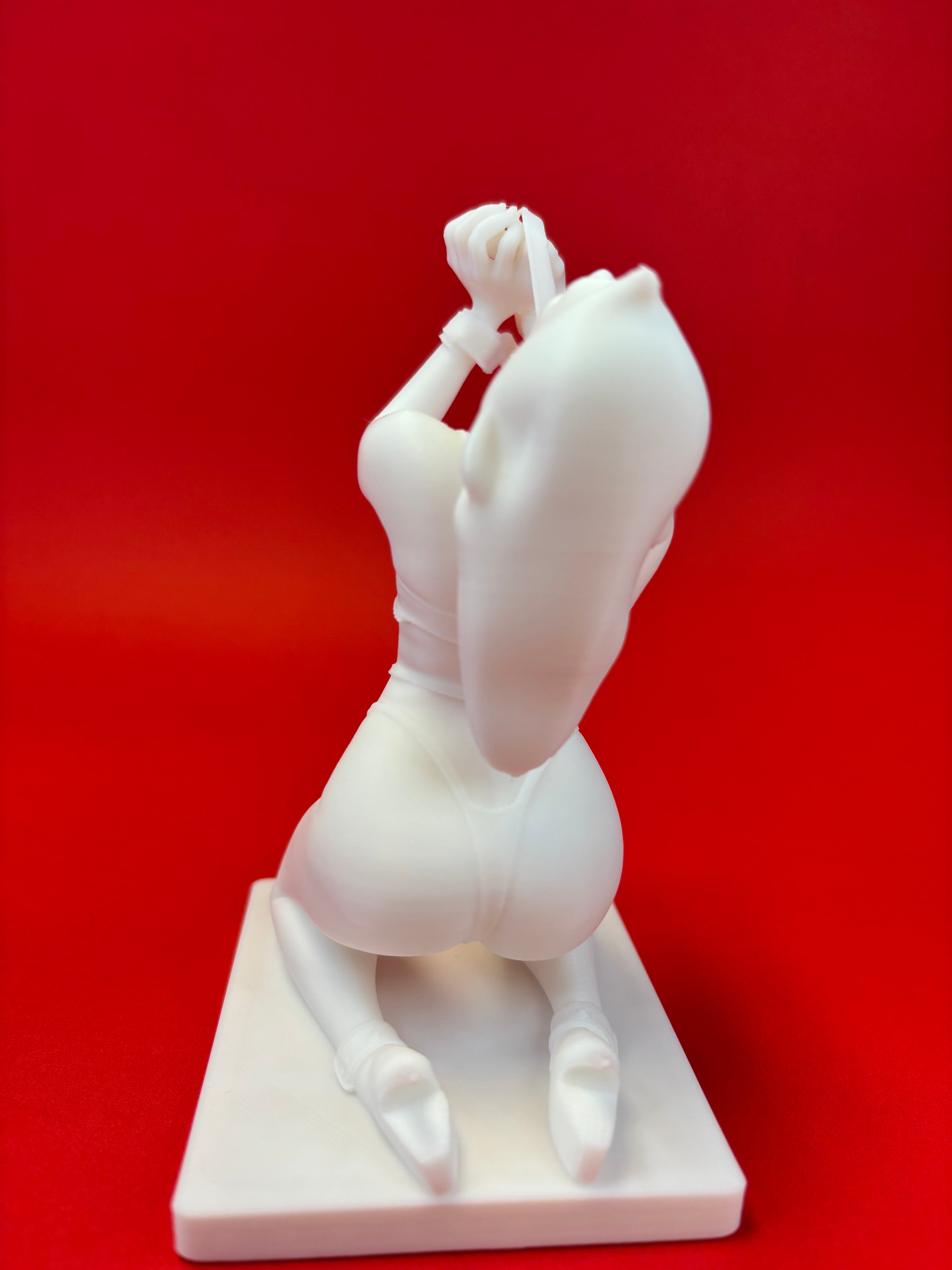 White sculpture of a figure on a red background