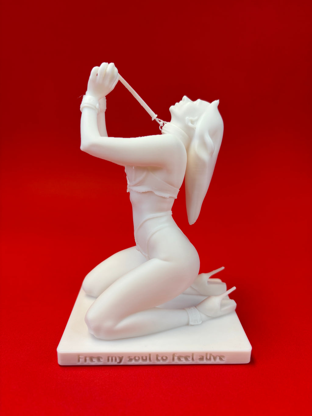 White sculpture of a reclining figure on a red background