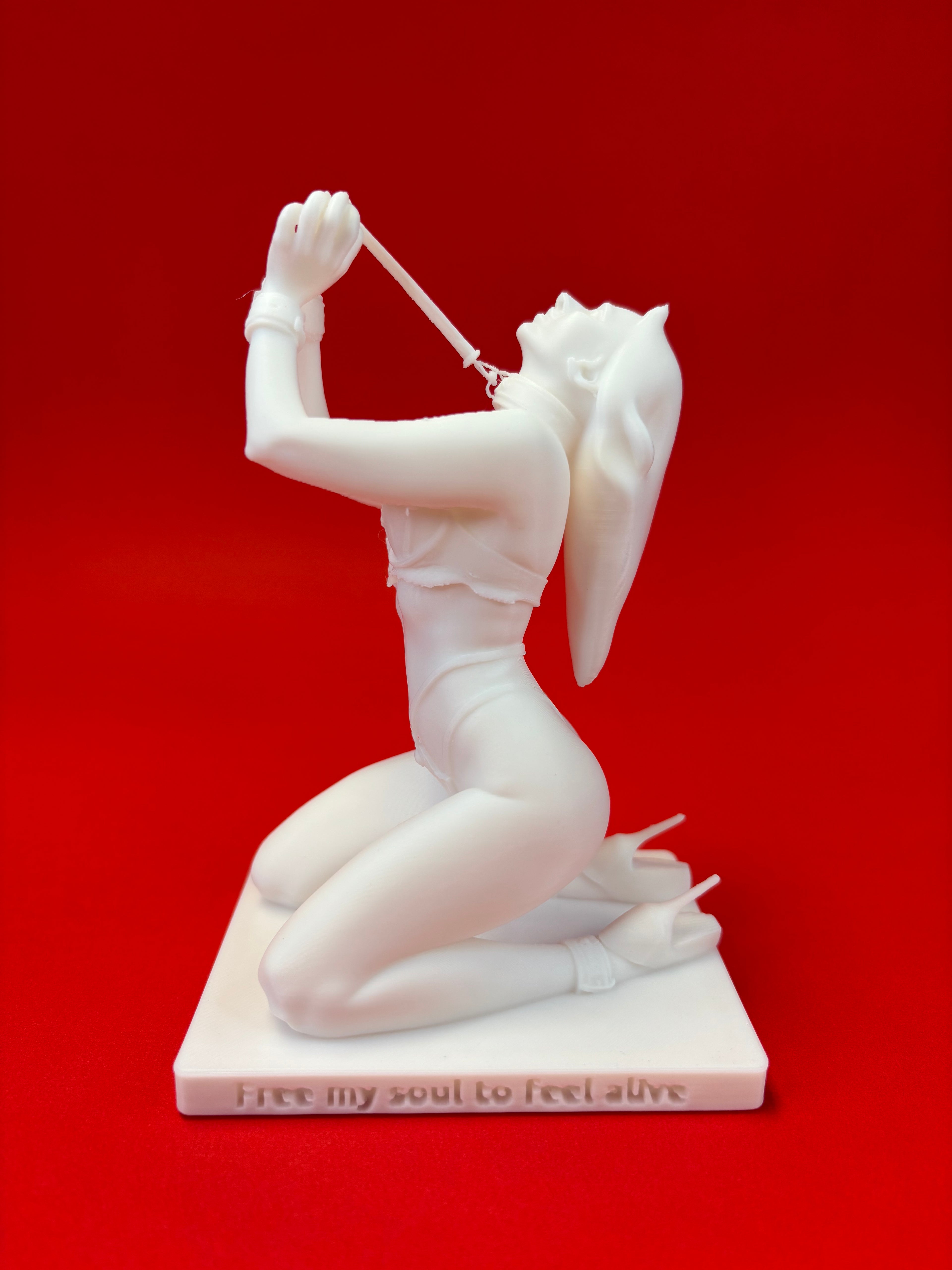 White sculpture of a reclining figure on a red background