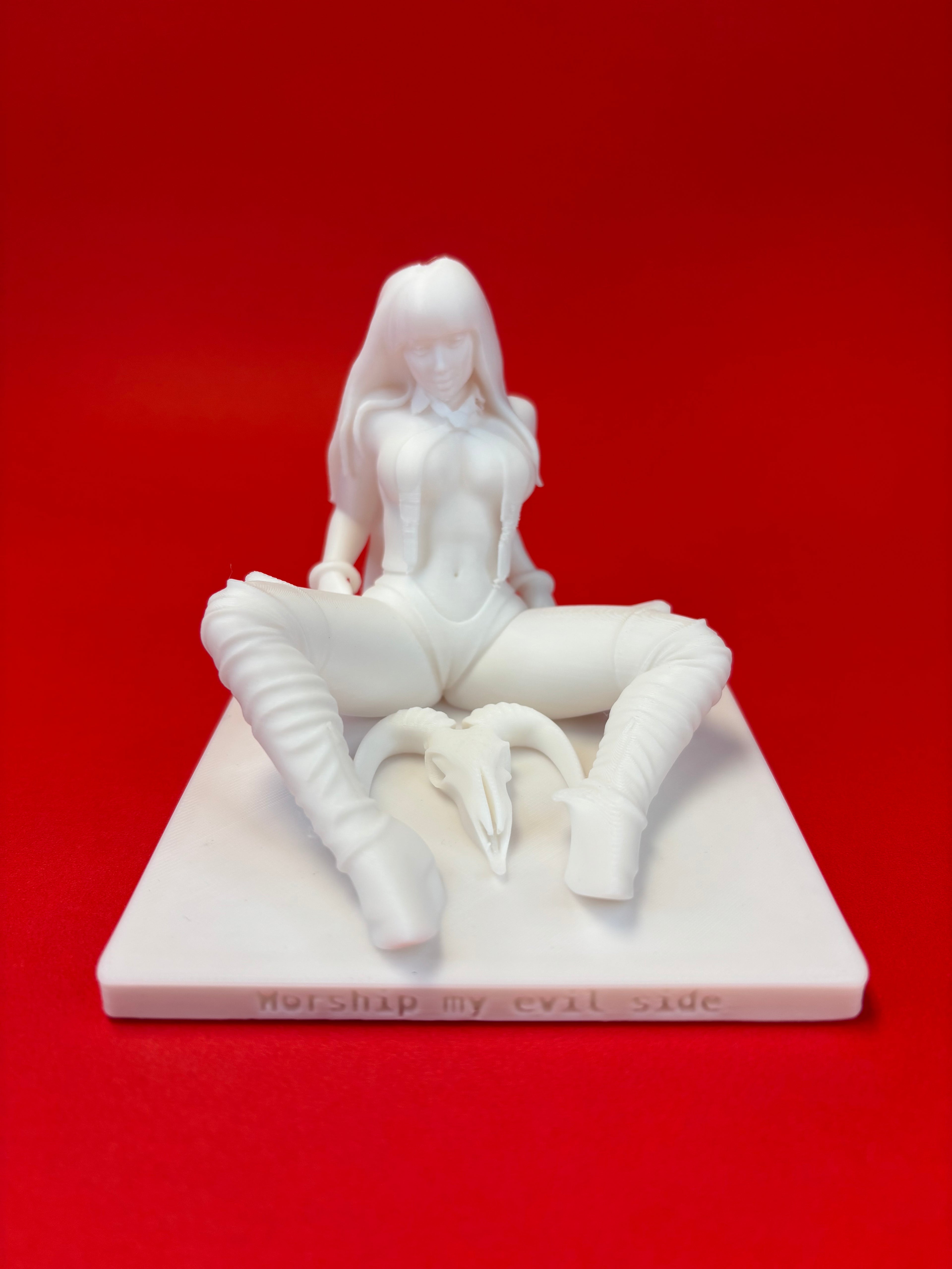 White figurine of a seated woman on a red background
