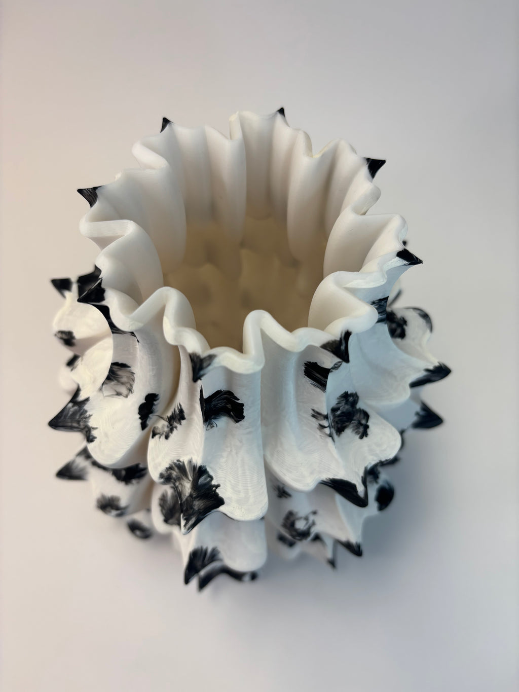 White vase with black patterns on a light gray background