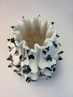 White vase with black patterns on a light gray background