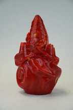 A glossy red sculptural object with a pointed top and organic, abstract form, photographed against a plain light gray studio background.