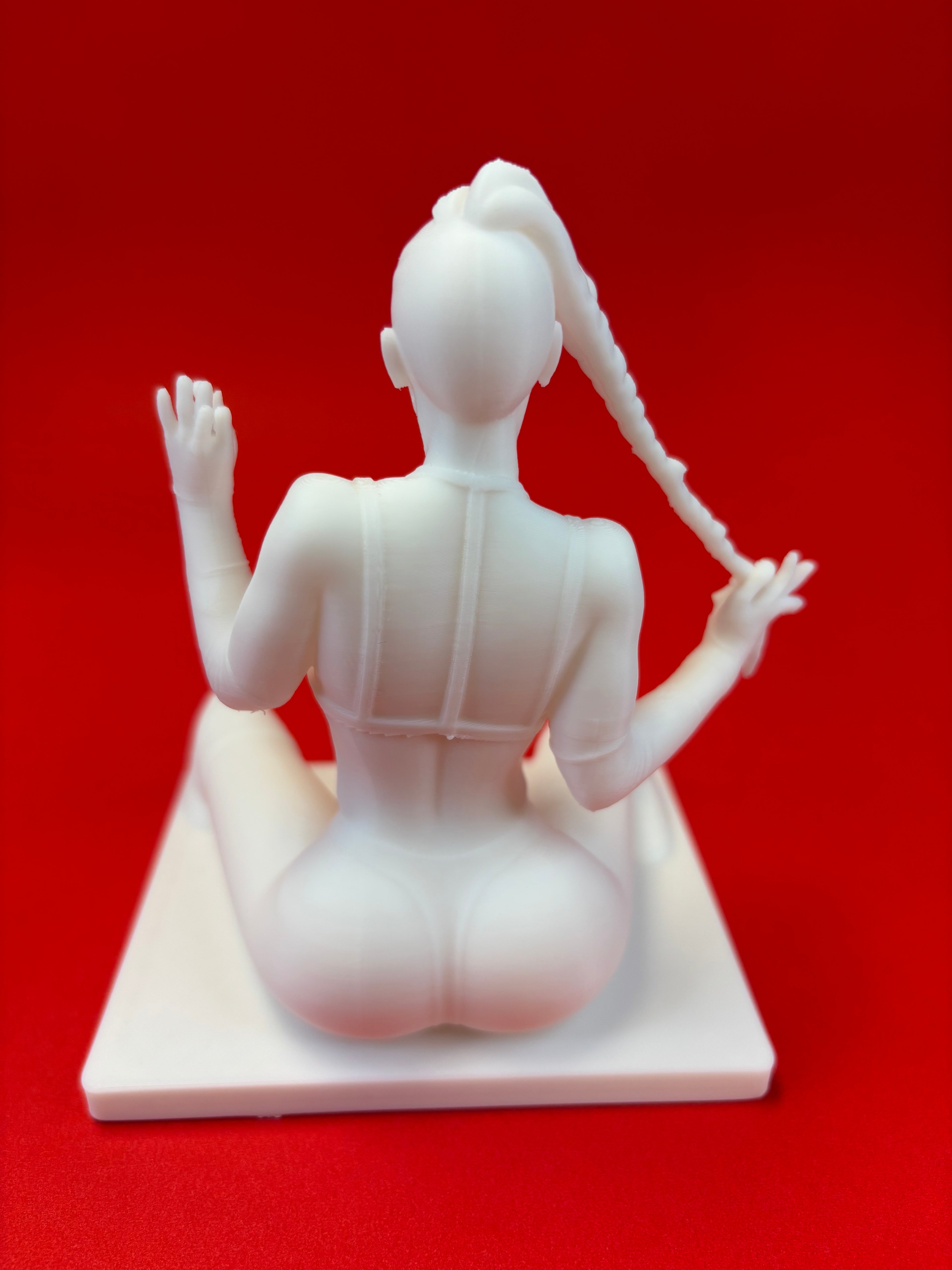 White sculpture of a figure on a red background