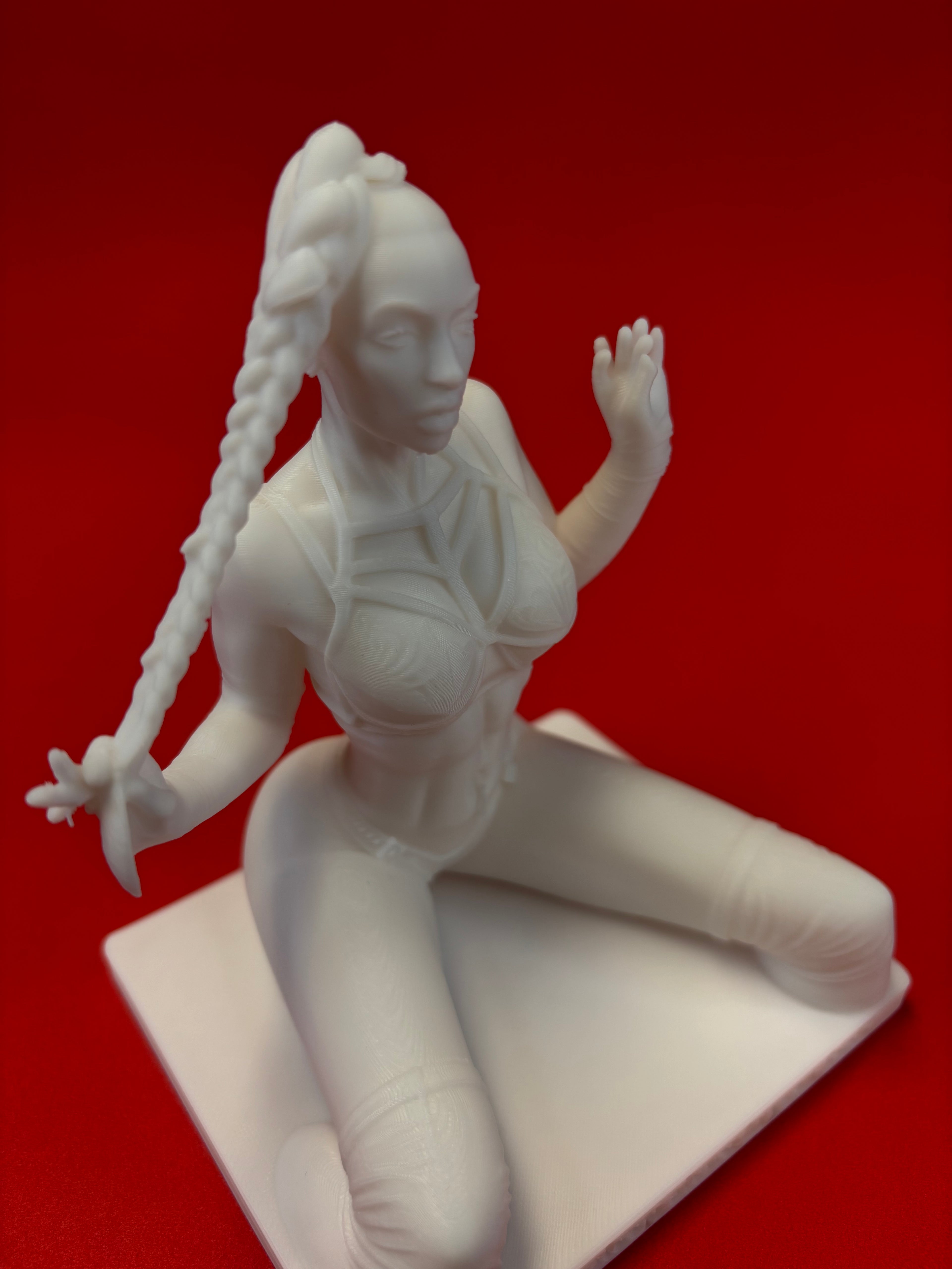 White sculpture of a reclining figure on a red background