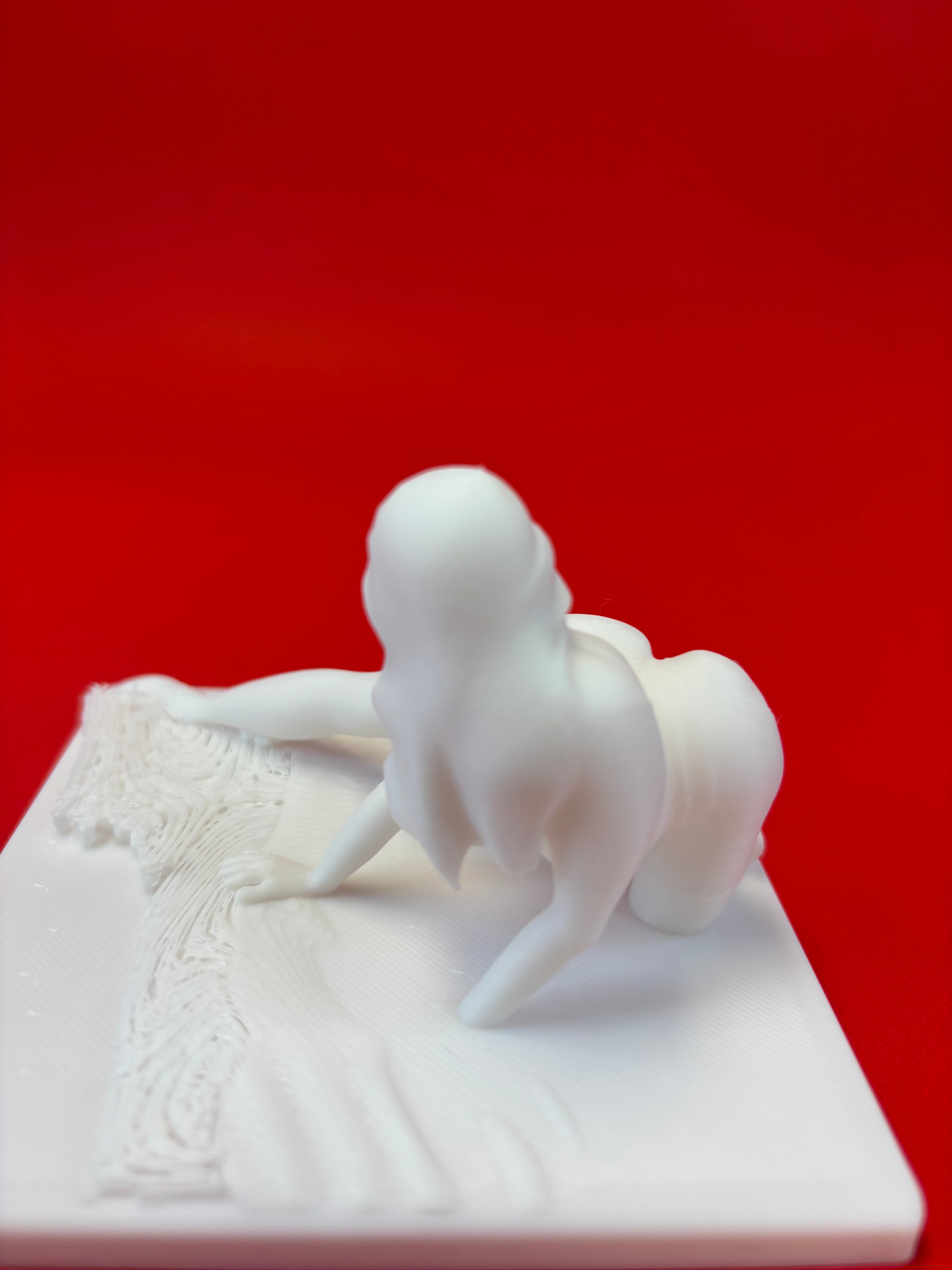 White ceramic sculpture embracing on a red background
