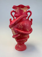 A red and beige marbled clay sculpture of a classical vase with twisted handles, photographed against a plain white background.