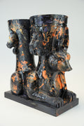 A sculptural black and orange marbled ceramic vessel set featuring a seated Anubis jackal motif on a rectangular base, photographed against a light gray studio background.