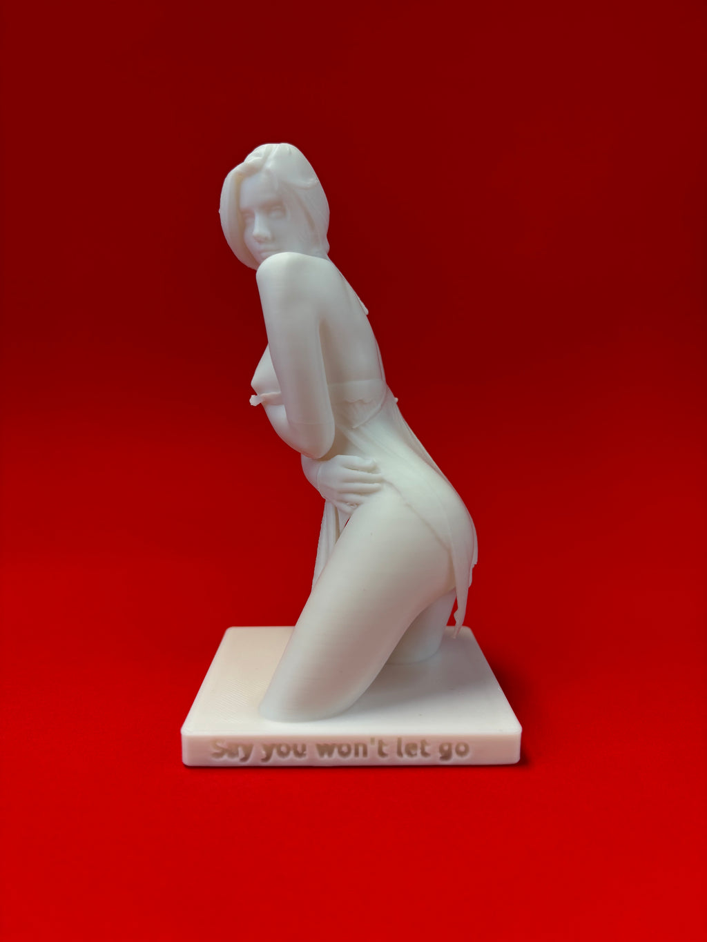 White sculpture of a nude figure on a red background
