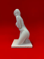 White sculpture of a nude figure on a red background