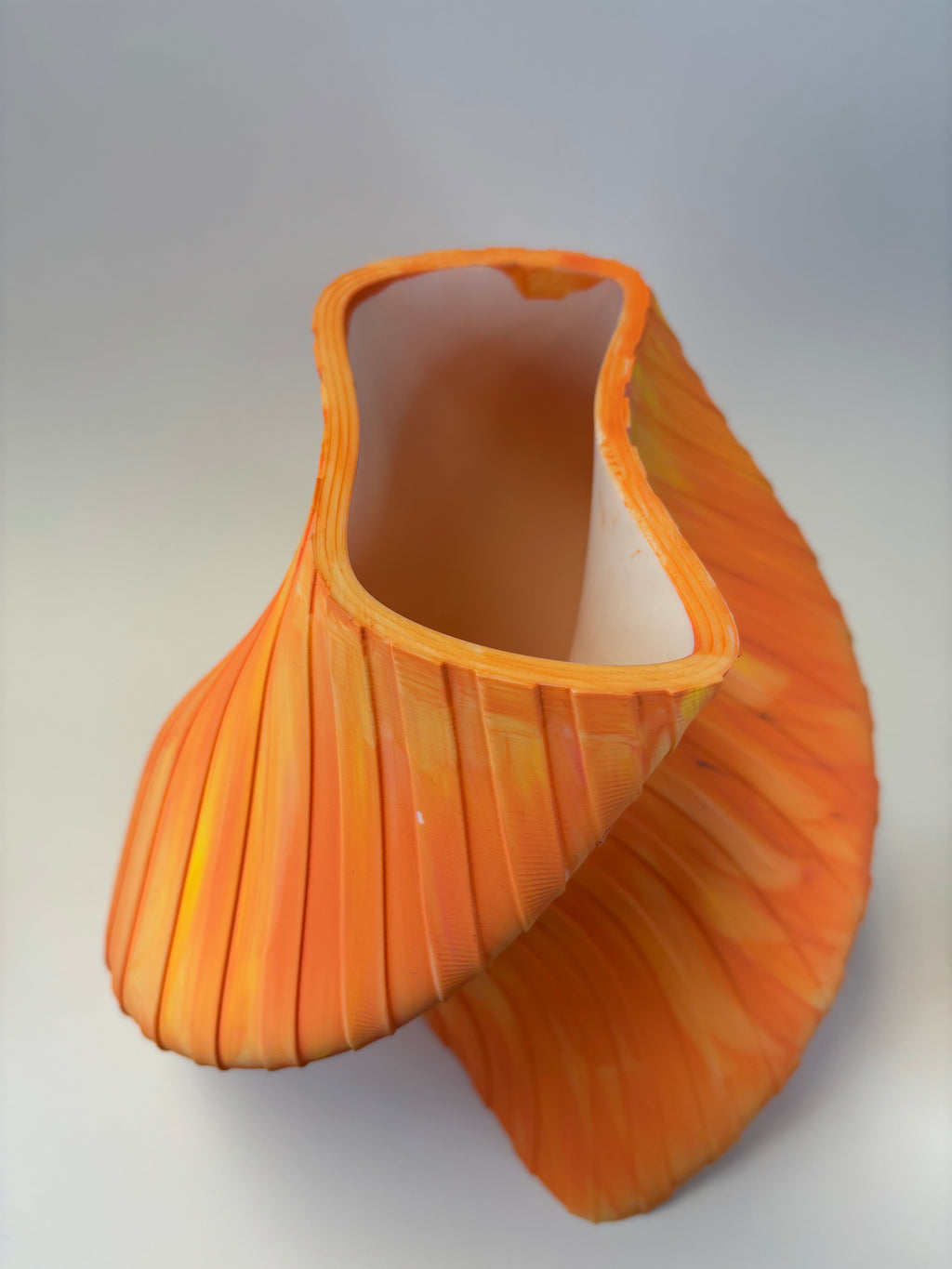 Orange decorative vase with wavy pattern and stripes.