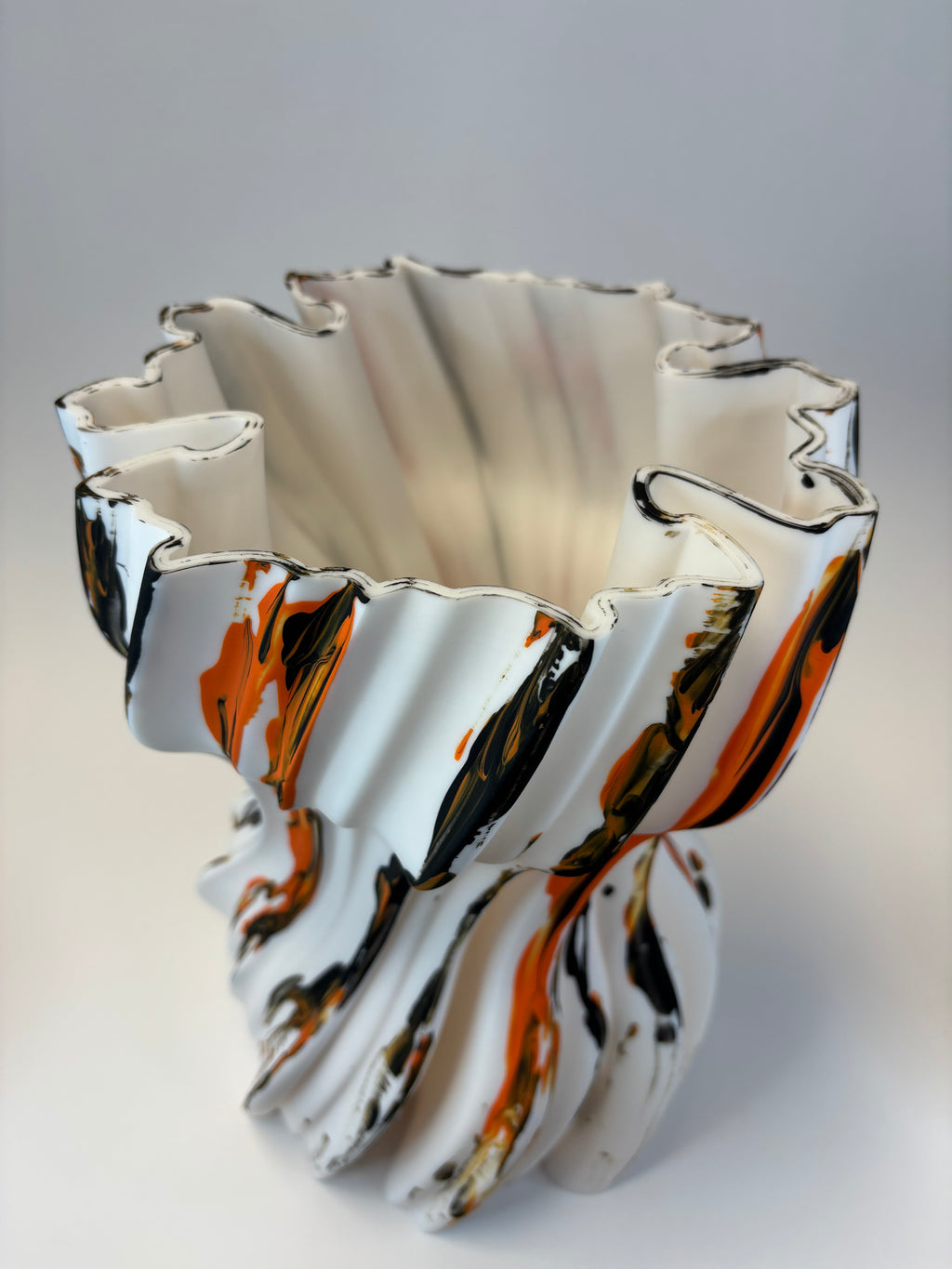 Abstract vase with wavy lines in black, white, and orange.