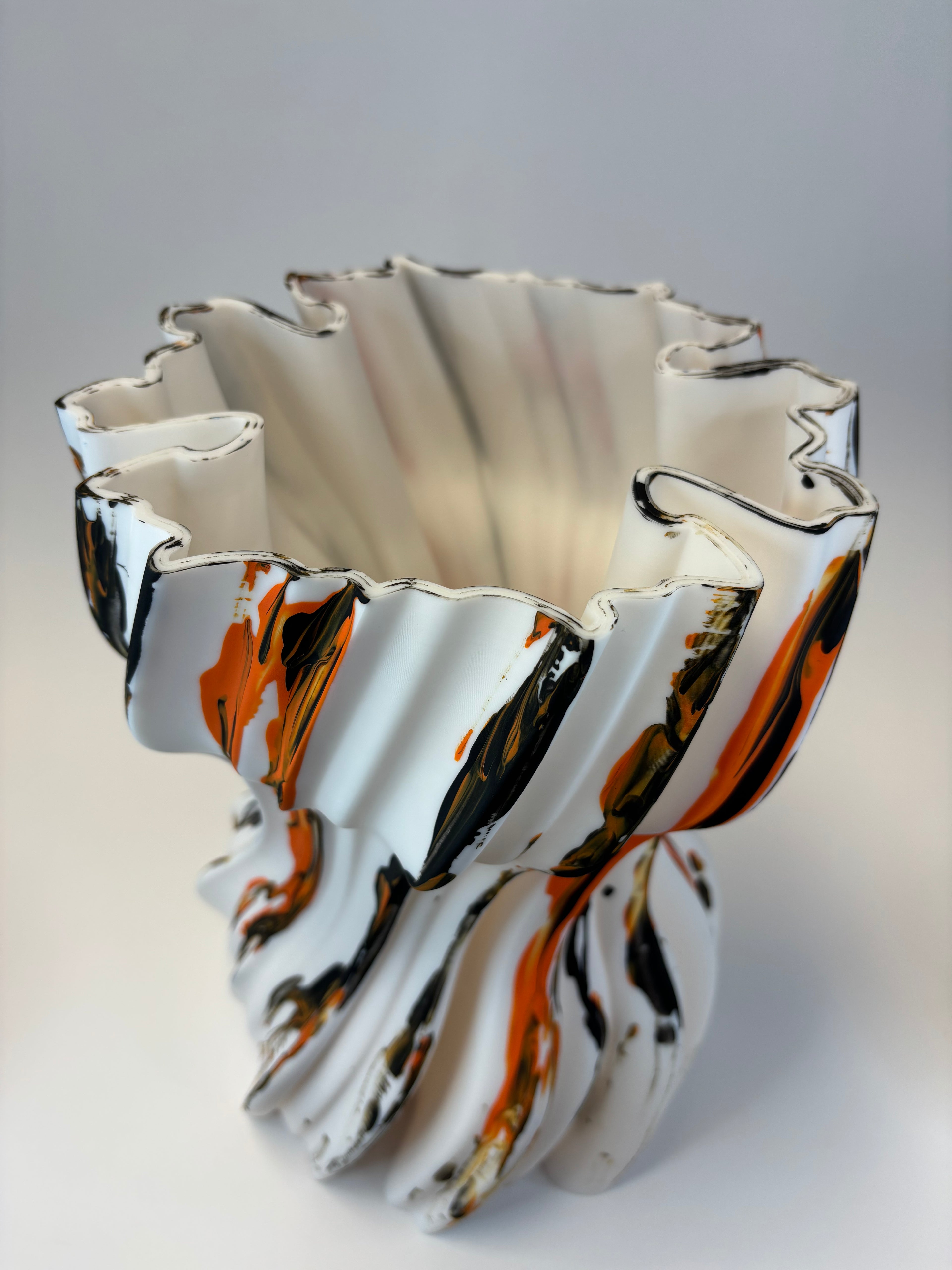 Abstract vase with wavy lines in black, white, and orange.