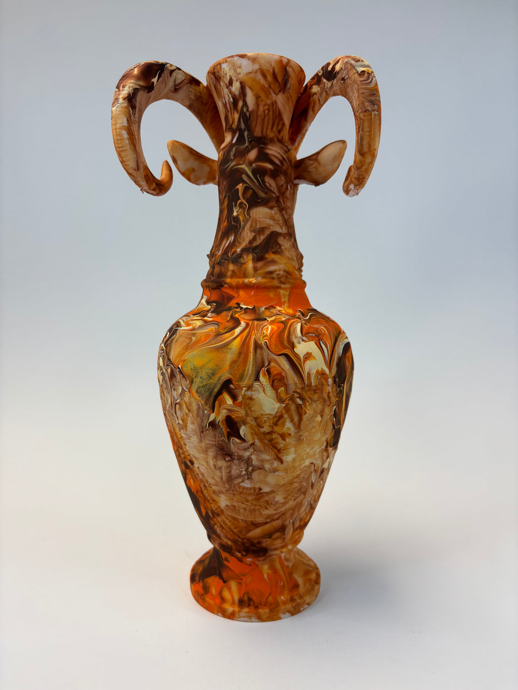 Decorative vase with marbled brown and orange design on a light gray background