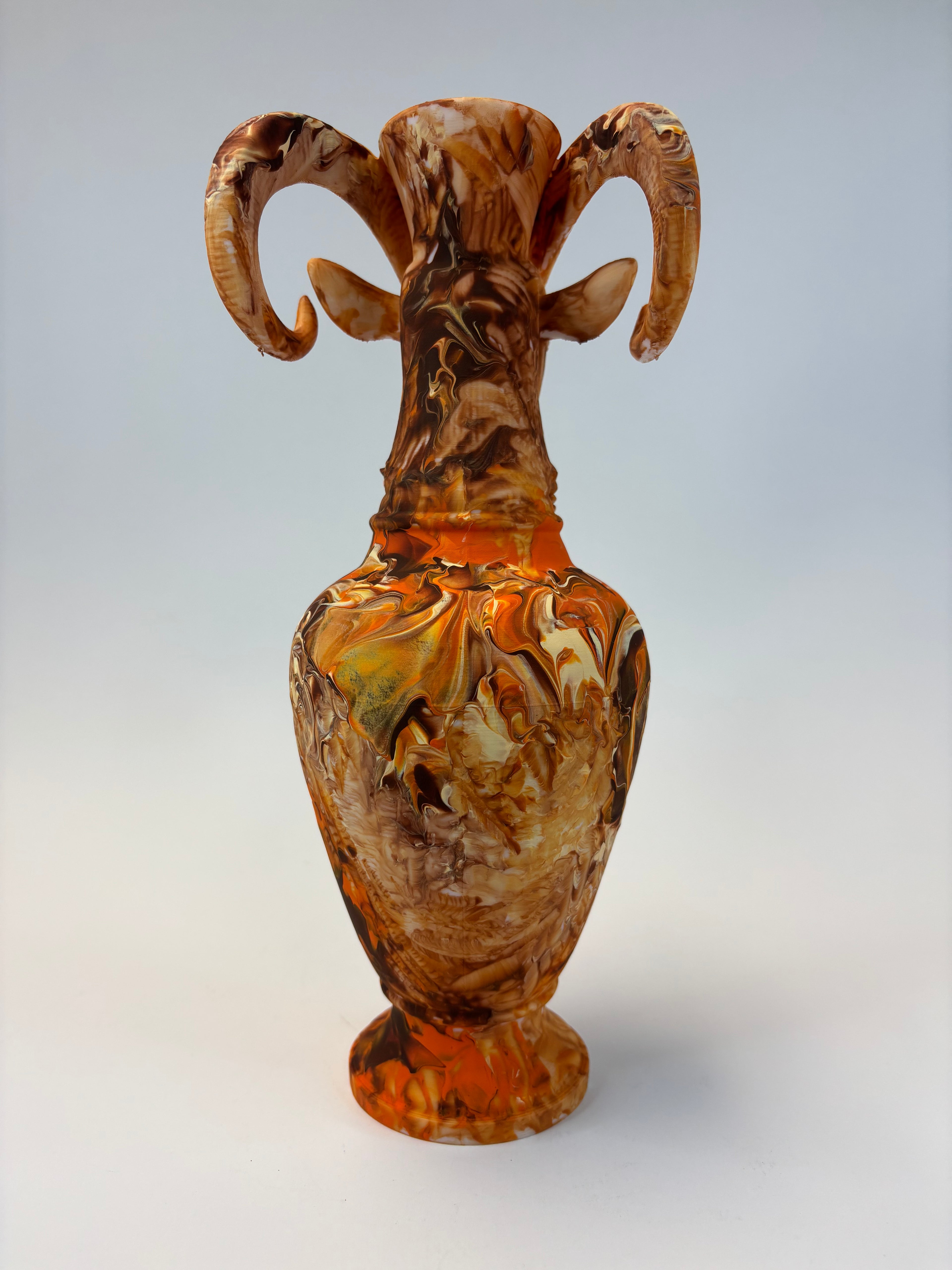 Decorative vase with marbled brown and orange design on a light gray background