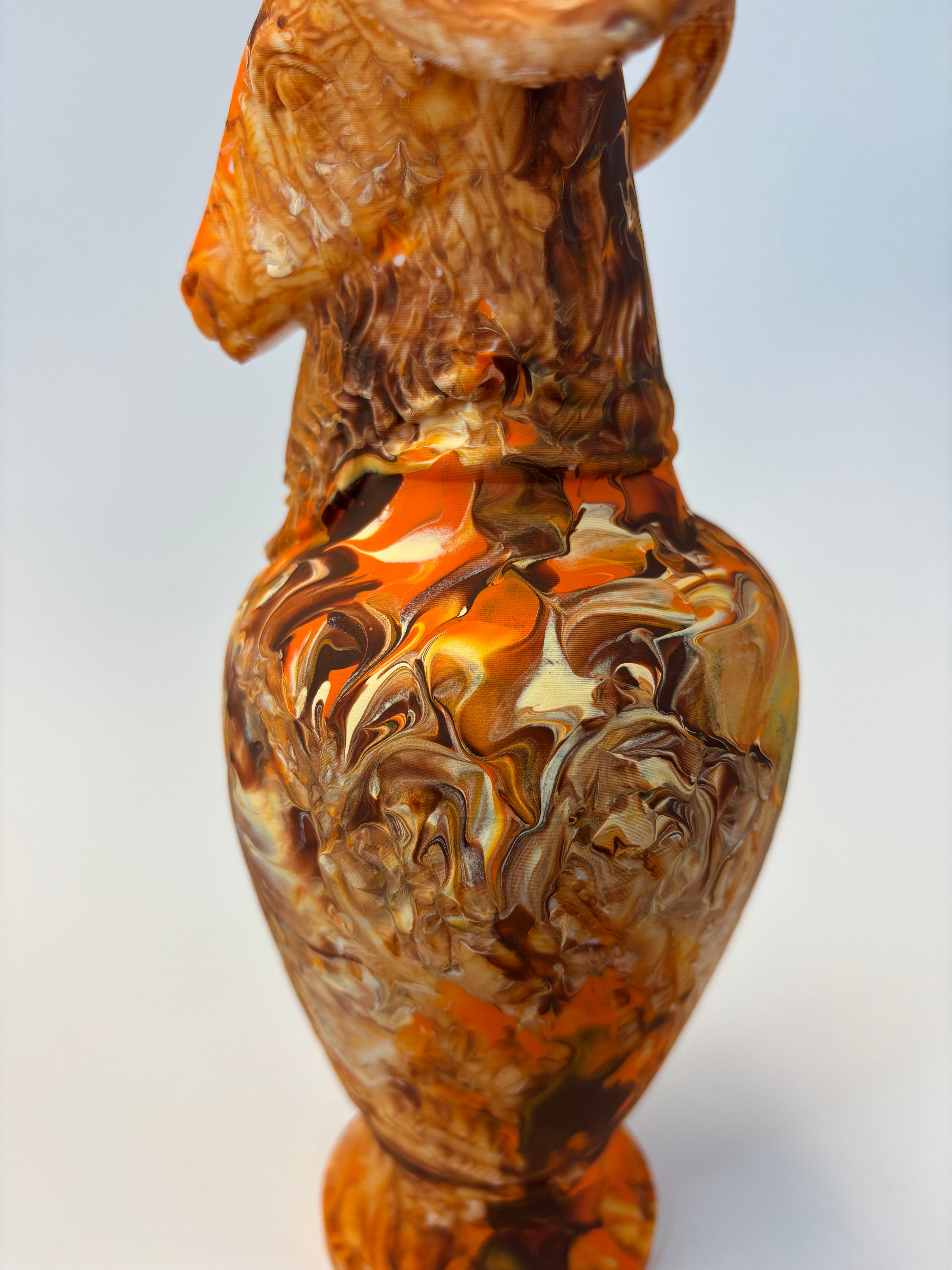 Marbled orange and brown vase on a white background