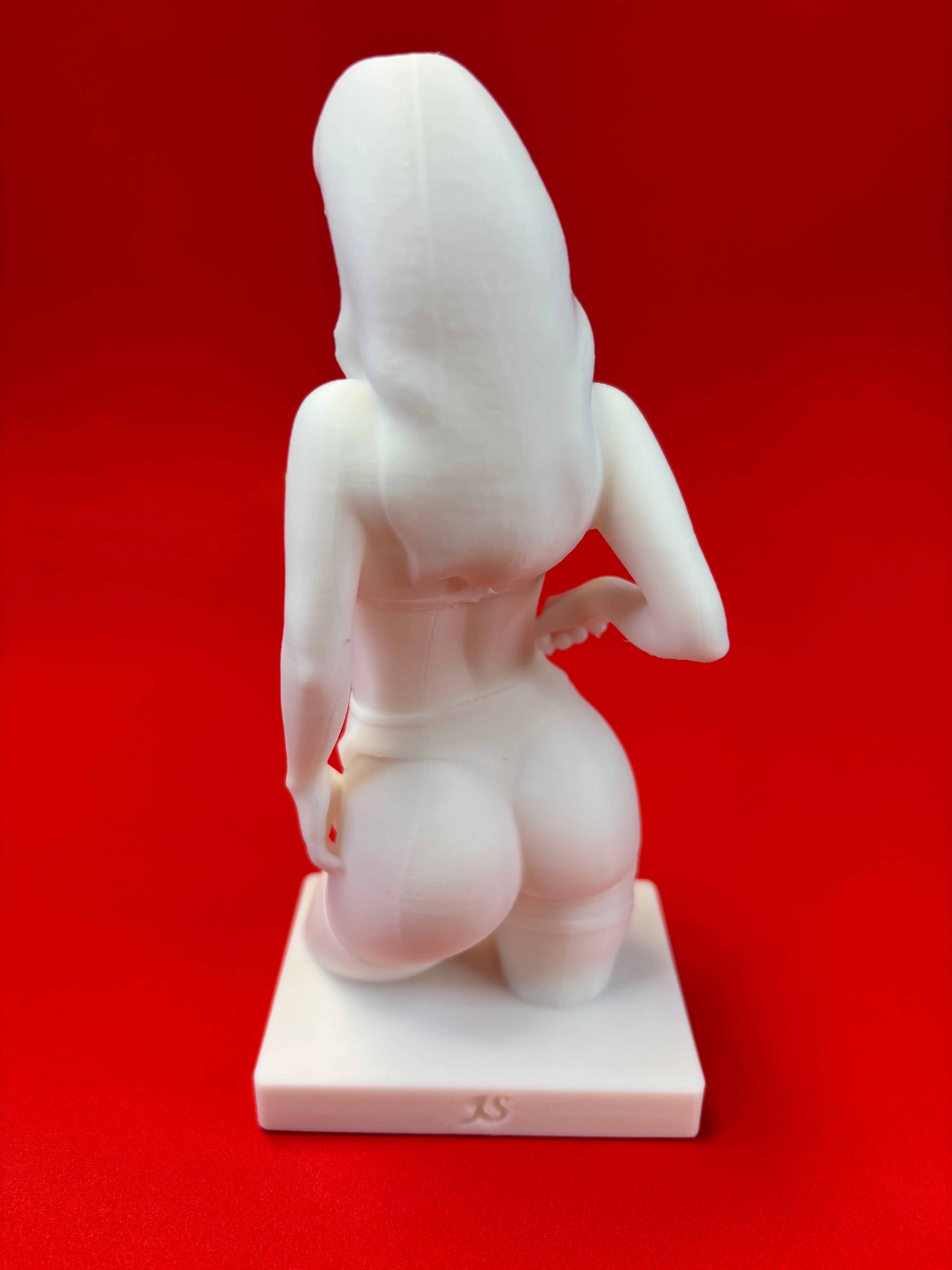 White sculpture of a figure on a red background