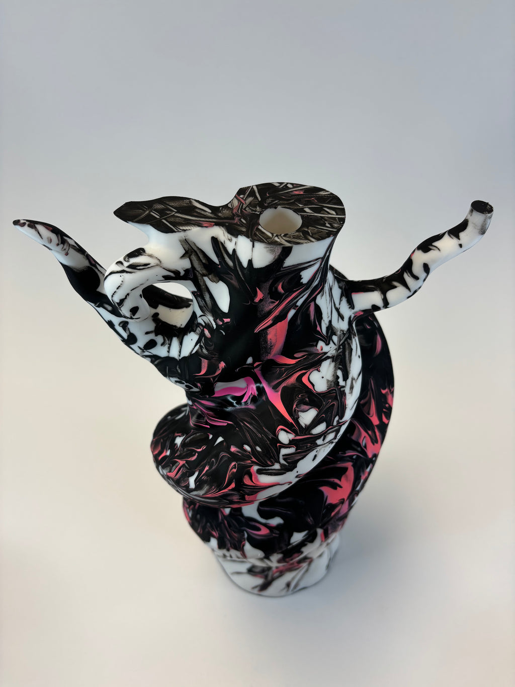 Decorative vase with black, white, and pink abstract design on a white background