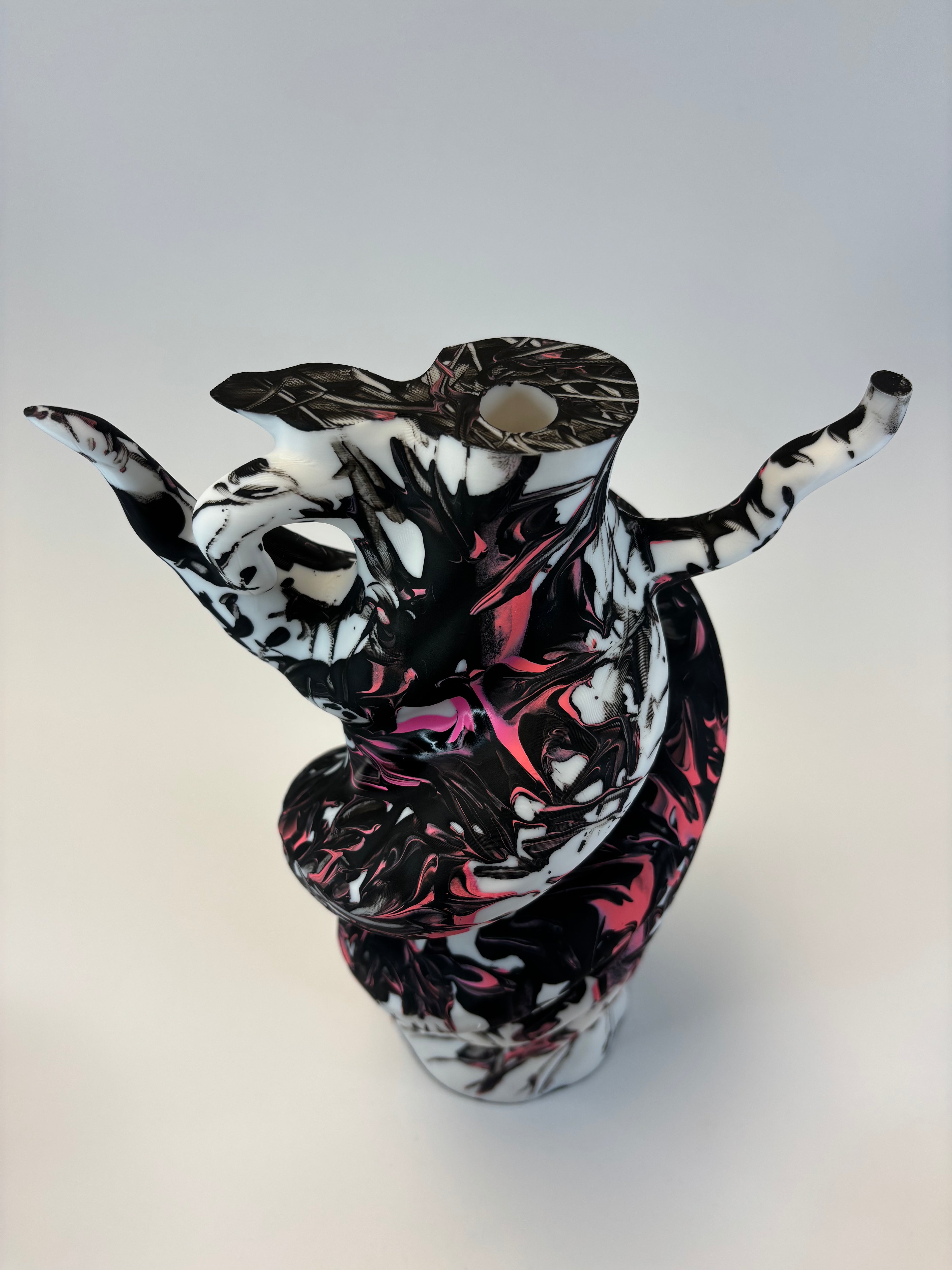 Decorative vase with black, white, and pink abstract design on a white background