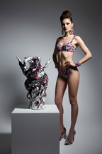 Woman in a floral bikini standing next to a decorative vase on a gray background