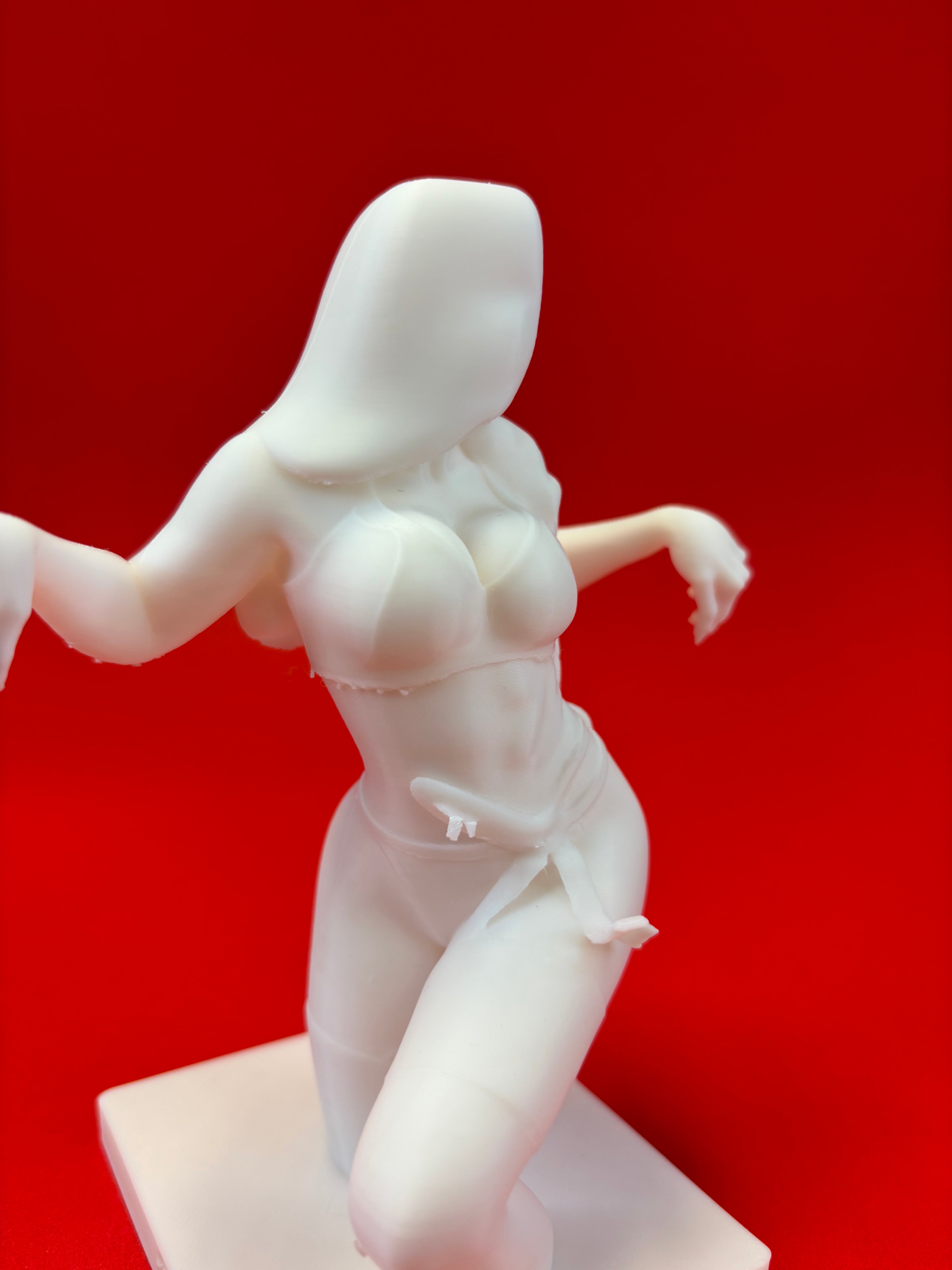 White sculpture of a woman on a red background