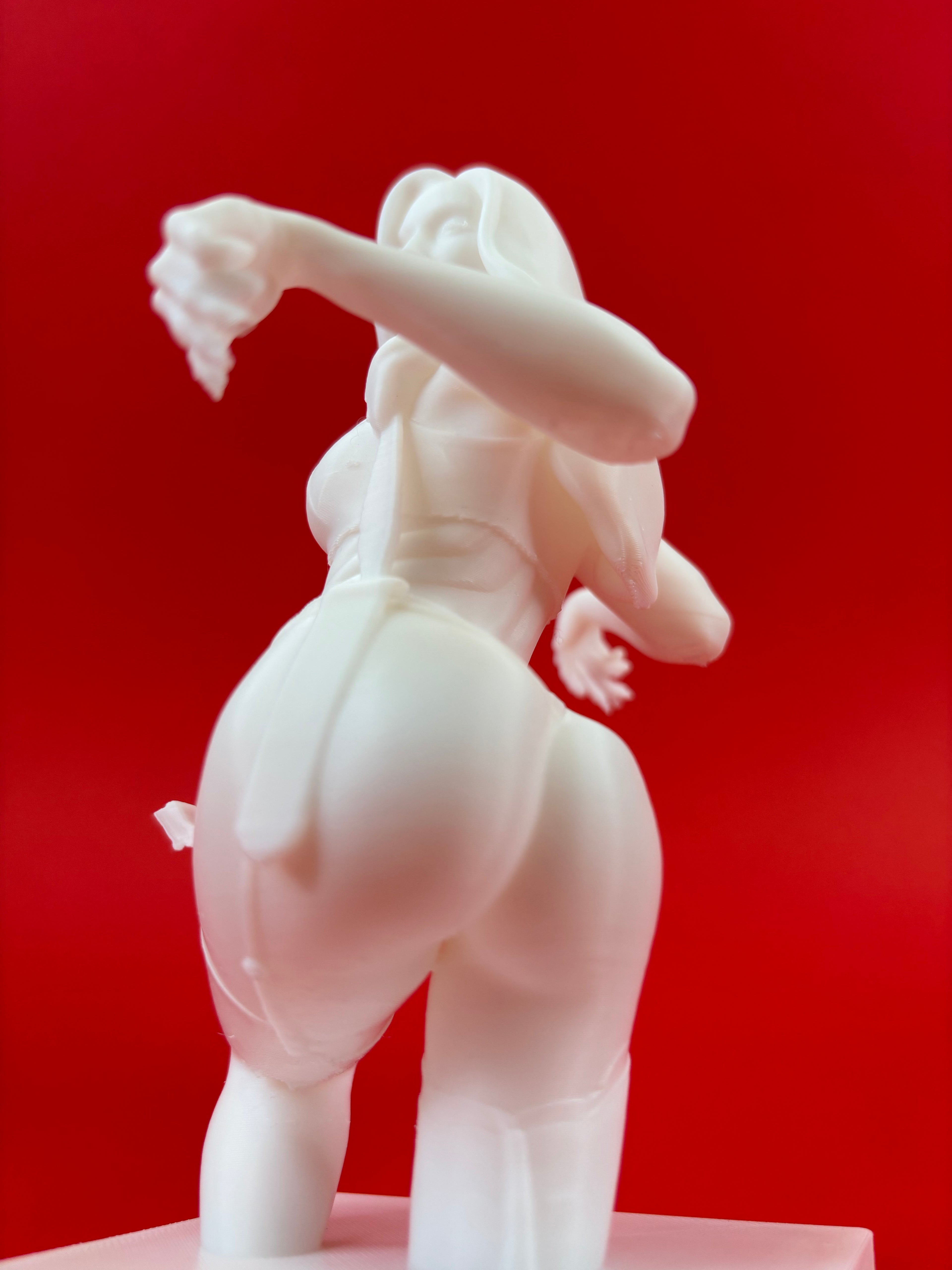White figurine of a woman against a red background