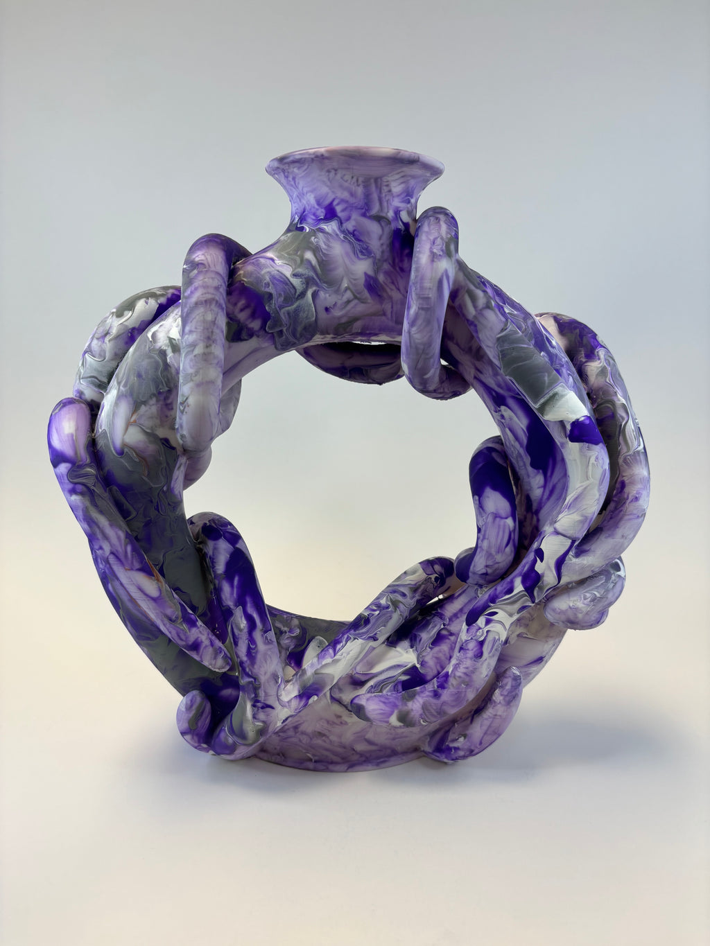 Purple and gray marbled ring vase on a light gray background