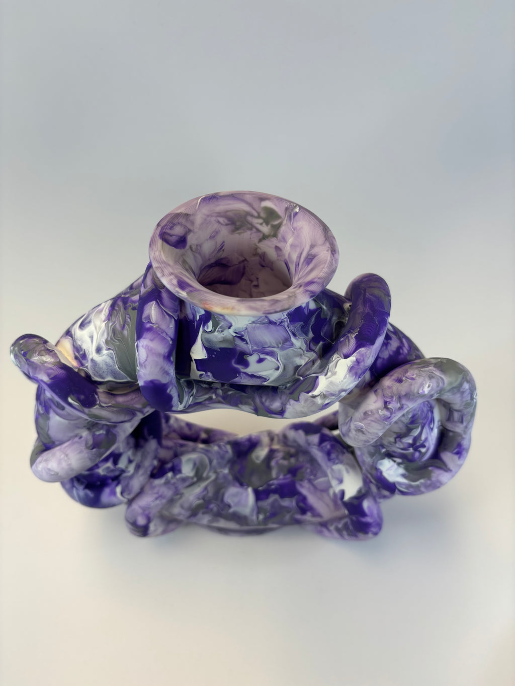 Purple and white marbled vase on a light gray background