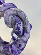 Close-up of a purple and white marbled object on a light background
