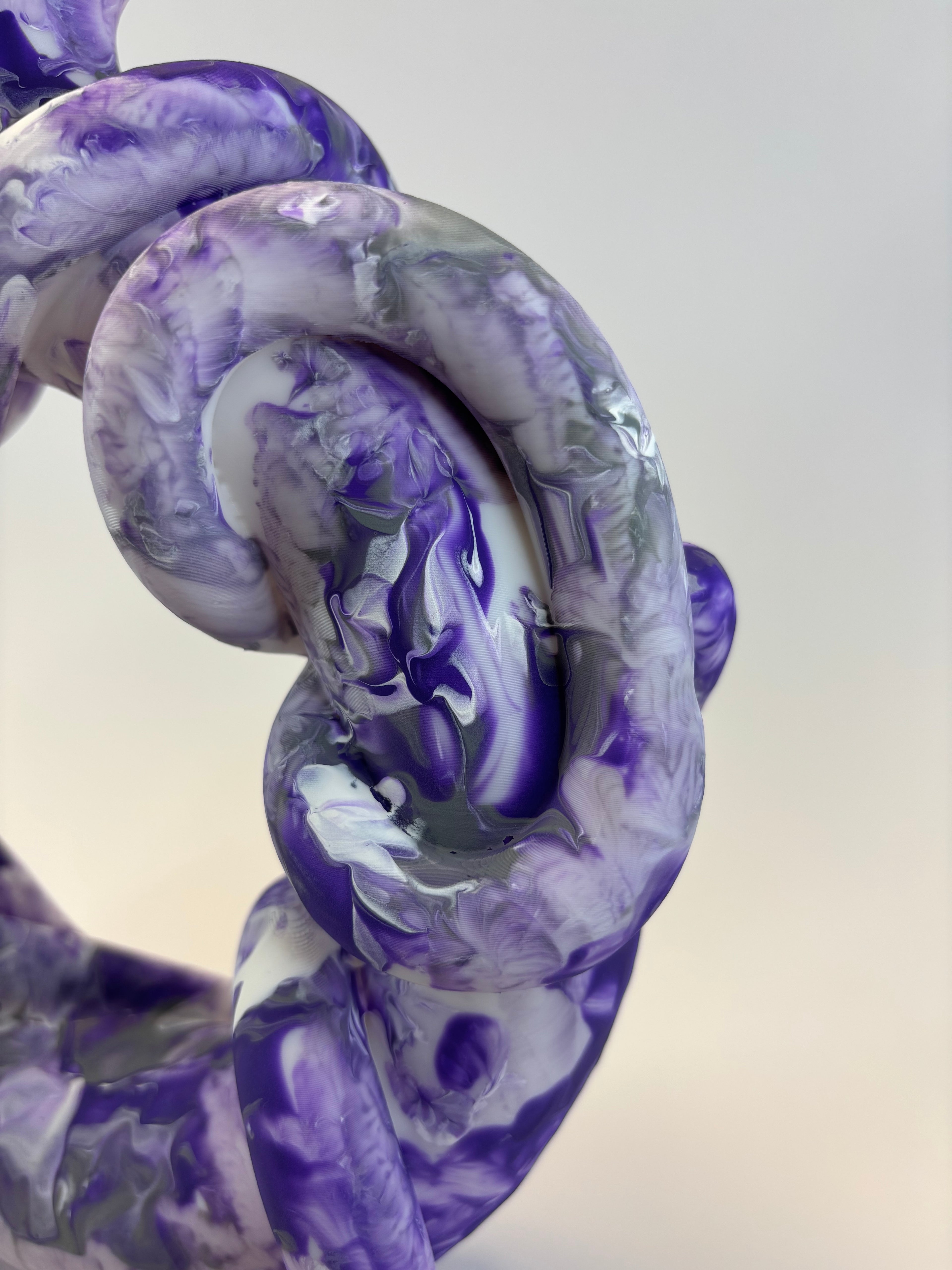 Close-up of a purple and white marbled object on a light background